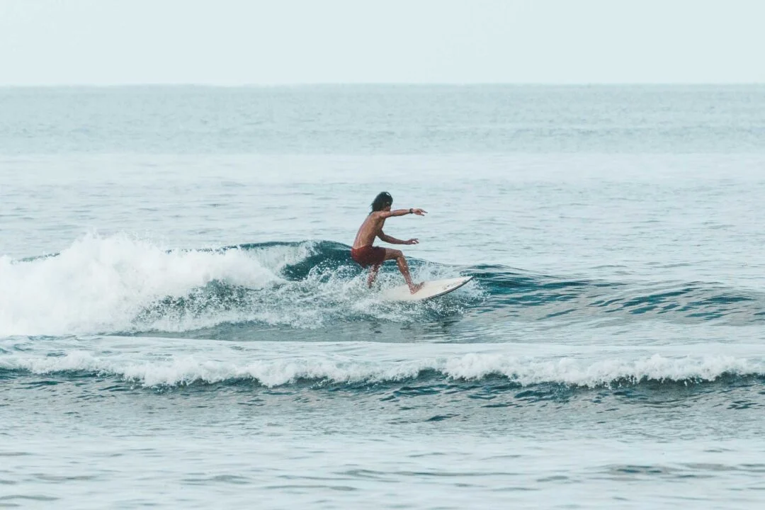 Surfer riding a wave at Pacifico Beach (Big Wish), north Siargao — an uncrowded left-hand reef break